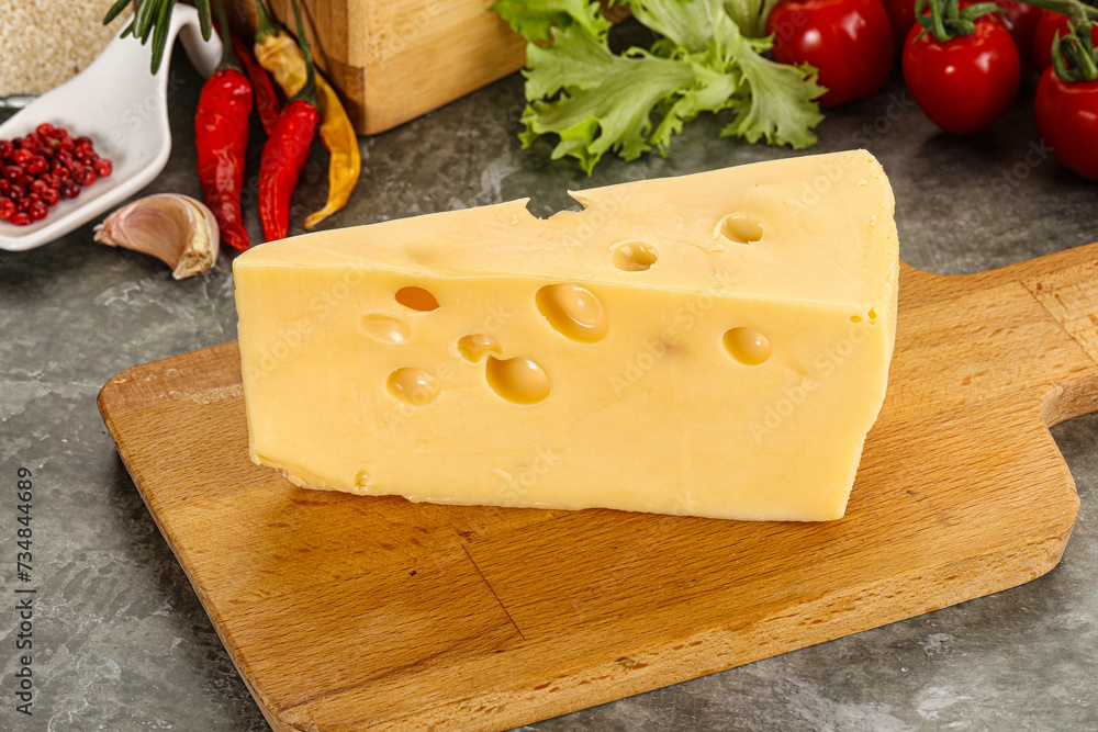 Swiss Maasdam cheese triangle over board Swiss Maasdam cheese triangle over board