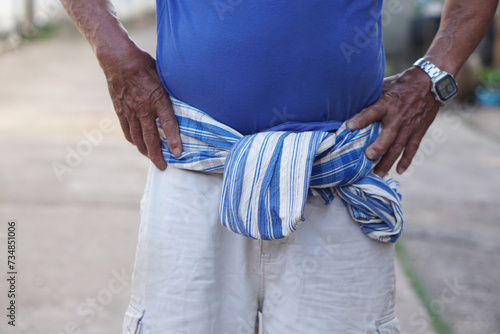 Close up Thai loincloth tied on waist of senior man. Concept, local man fashion in Thailand. Traditional lifestyle.  Loincloth is a multi-purpose cloth that Thai people have used since ancient times. 