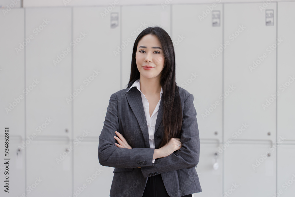 Happy asian young businesswoman arms crossed standing in office working space. Happy asian young businesswoman arms crossed standing in office working space.