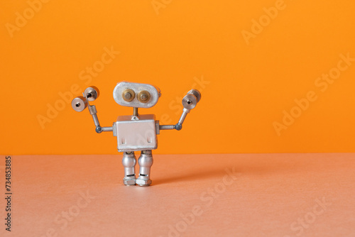 Robot athlete holds dumbbells. sports exercise fitness training. orange brown background