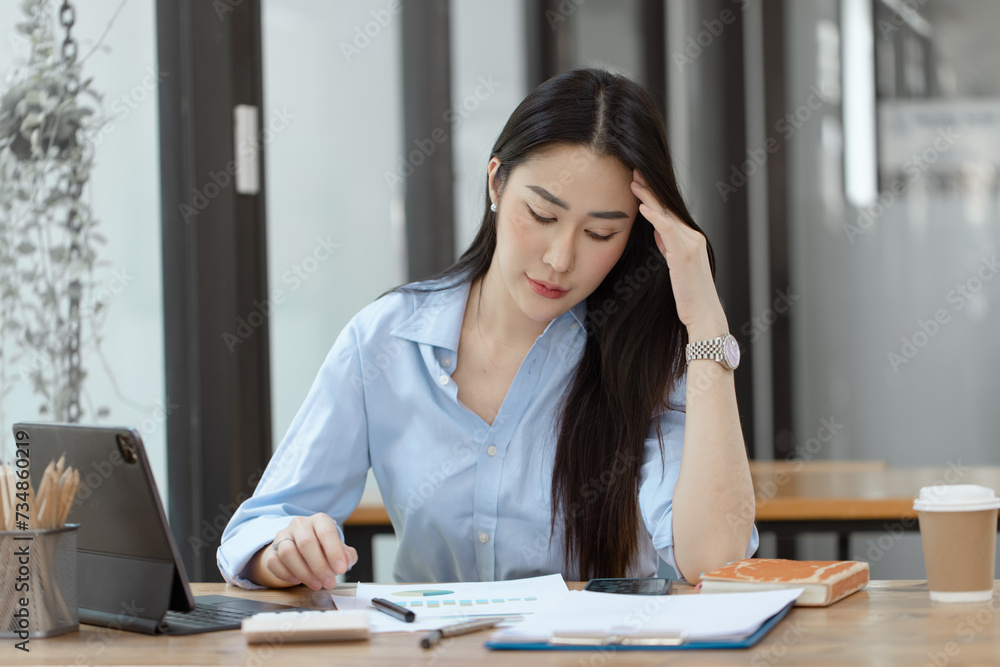 Asian businesswoman are stressed and tired from work sitting at desk in the office, feeling sick at work, stress from work. Asian businesswoman are stressed and tired from work sitting at desk in the office, feeling sick at work, stress from work.