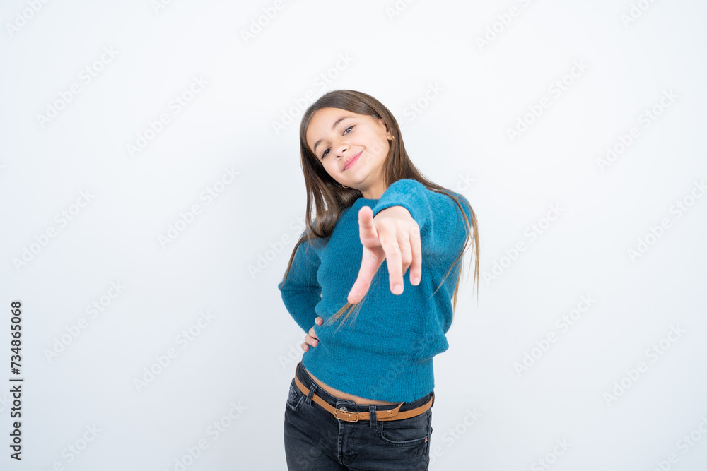 Young beautiful teen girl wearing blue T-shirt pointing at camera with a satisfied, confident, friendly smile, choosing you Young beautiful teen girl wearing blue T-shirt pointing at camera with a satisfied, confident, friendly smile, choosing you