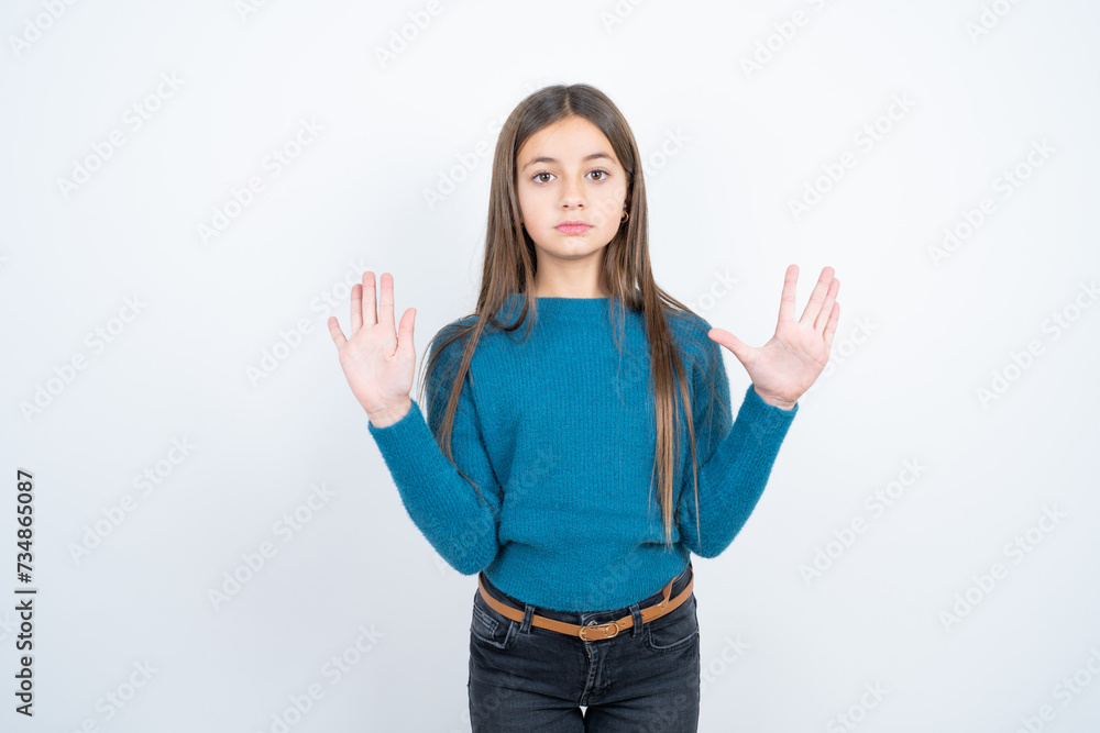 Serious Young beautiful teen girl wearing blue T-shirt pulls palms towards camera, makes stop gesture, asks to control your emotions and not be nervous Serious Young beautiful teen girl wearing blue T-shirt pulls palms towards camera, makes stop gesture, asks to control your emotions and not be nervous