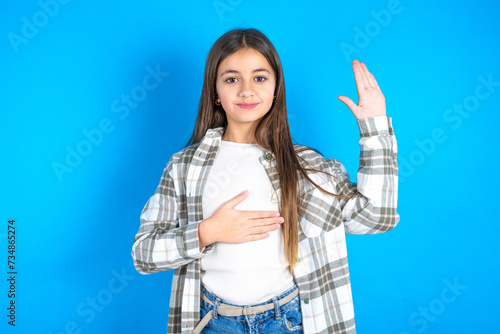 Young beautiful teen girl wearing check shirt Swearing with hand on chest and open palm, making a loyalty promise oath photo