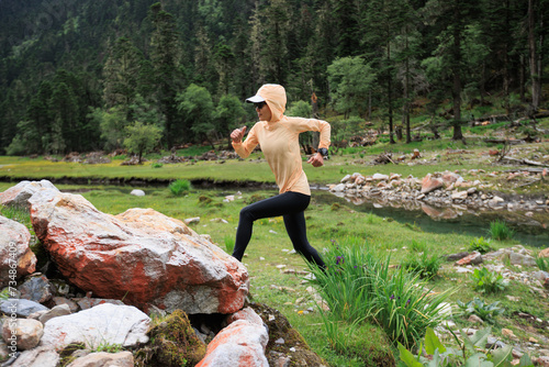 Woman trail runner cross country running in high altitude mountains photo