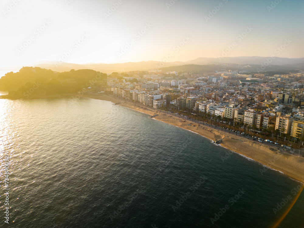 Aerial view of Lloret del Mar City. Mediterranean coastal town in Catalonia, Spain. One of the most popular Costa Brava beaches and travel destination. Panoramic view of all region Sunset warm colours
