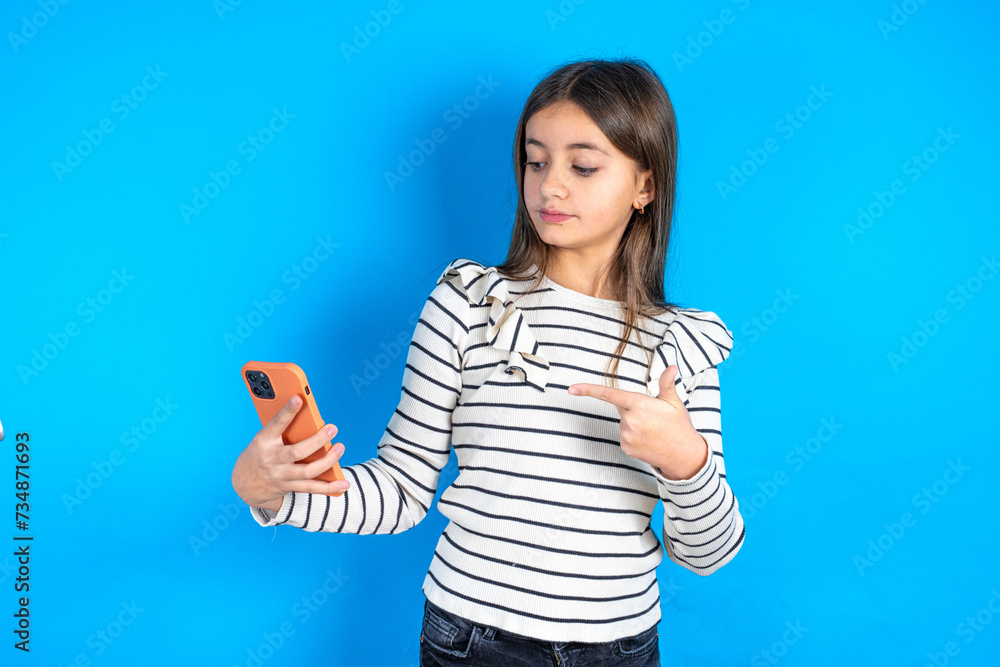 Young beautiful teen girl wearing striped T-shirt holding in hands showing new cell, Young beautiful teen girl wearing striped T-shirt holding in hands showing new cell,