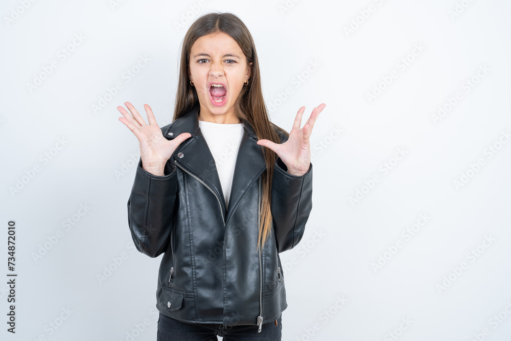 Crazy outraged Young beautiful teen girl wearing biker jacket screams loudly and gestures angrily yells furiously. Negative human emotions feelings concept