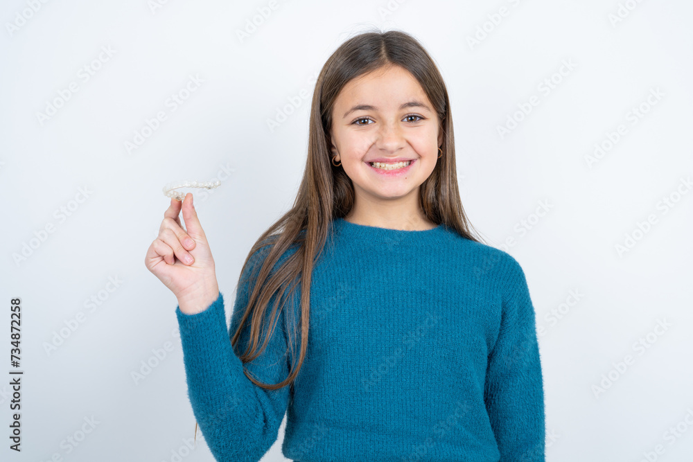 Young beautiful teen girl wearing blue T-shirt holding a toothbrush and smiling. Dental healthcare concept. Young beautiful teen girl wearing blue T-shirt holding a toothbrush and smiling. Dental healthcare concept.