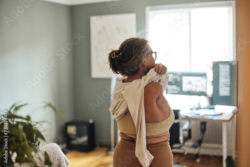 Rear view of mature woman with disability wearing dress at home photo