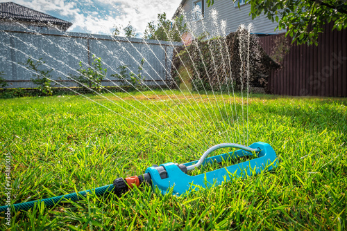 Lawn sprinkler watering green grass