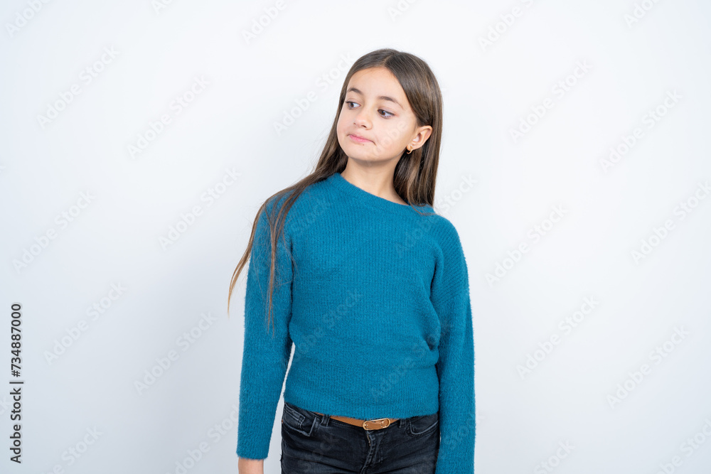 beautiful kid girl wearing blue sweater looking aside into empty space thoughtful beautiful kid girl wearing blue sweater looking aside into empty space thoughtful