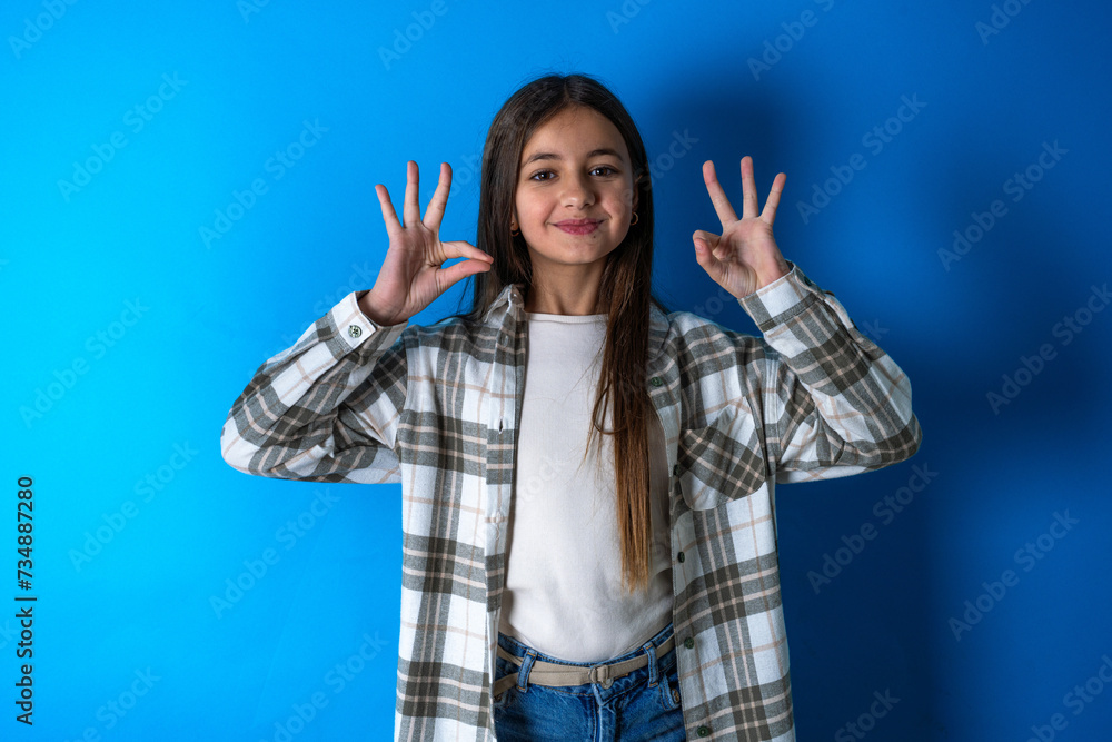 Beautiful kid girl wearing plaid shirt relax and smiling with eyes closed doing meditation gesture with fingers. Yoga concept. Beautiful kid girl wearing plaid shirt relax and smiling with eyes closed doing meditation gesture with fingers. Yoga concept.