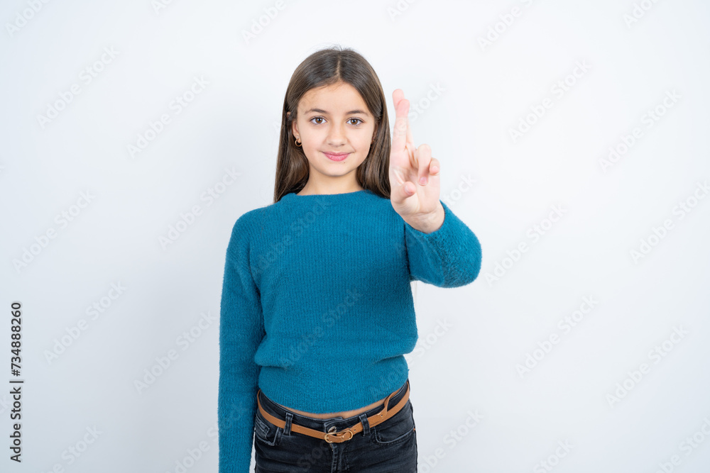 beautiful kid girl wearing blue sweater pointing up with fingers number ten in Chinese sign language Shi beautiful kid girl wearing blue sweater pointing up with fingers number ten in Chinese sign language Shi