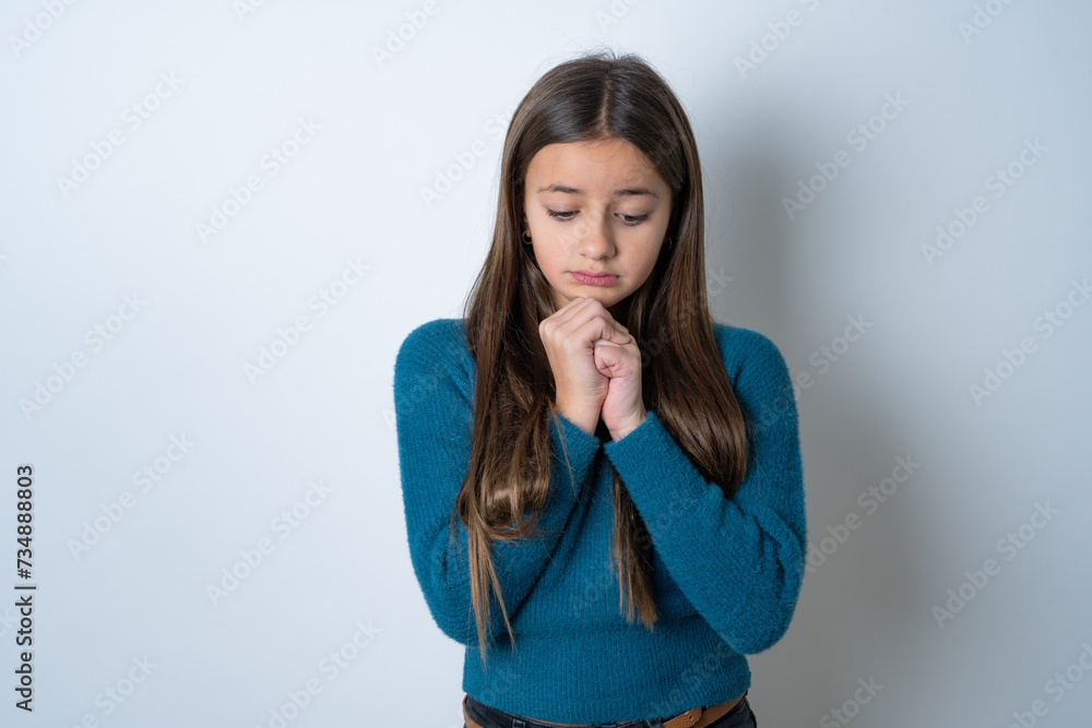 Sad beautiful kid girl wearing blue sweater desperate and depressed with tears on her eyes suffering pain and depression in sadness facial expression and emotion concept Sad beautiful kid girl wearing blue sweater desperate and depressed with tears on her eyes suffering pain and depression in sadness facial expression and emotion concept