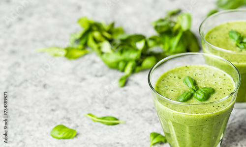 Healthy green basil smoothie on grey table. Copy space. 