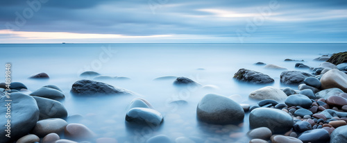 Ethereal seascape with smooth pebbles and misty horizon