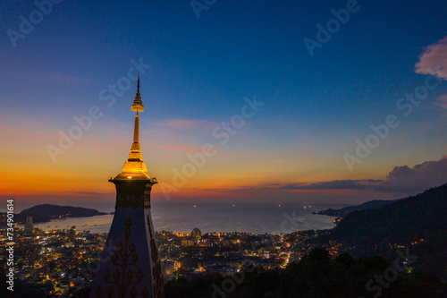 aerial view scenery sunset above pagoda of Doi Thepnimit temple on the highest of Patong mountain..The lights twinkle at twilight background..Scene of Colorful romantic sky sunset, beautiful pagoda. photo