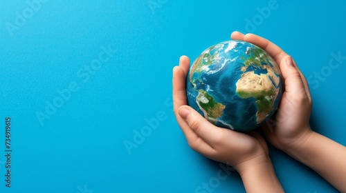 Caring hands cradle earth, symbolizing responsibility and love, on blue background with copy space