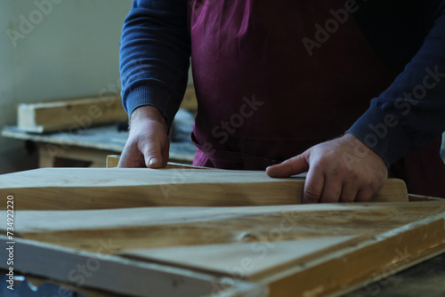 Artisan carefully positions a wooden slab in a resin mold. Precision here is key to crafting a seamless piece.