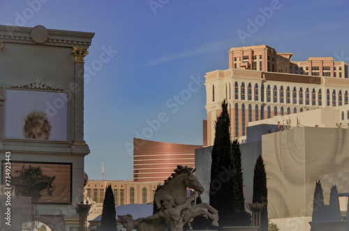 Neon signs, glitz casino hotel resorts, traffic and highrise city skyline in superlative gambling wedding party destination Las Vegas, Nevada with strip traffic street scene and modern architecture