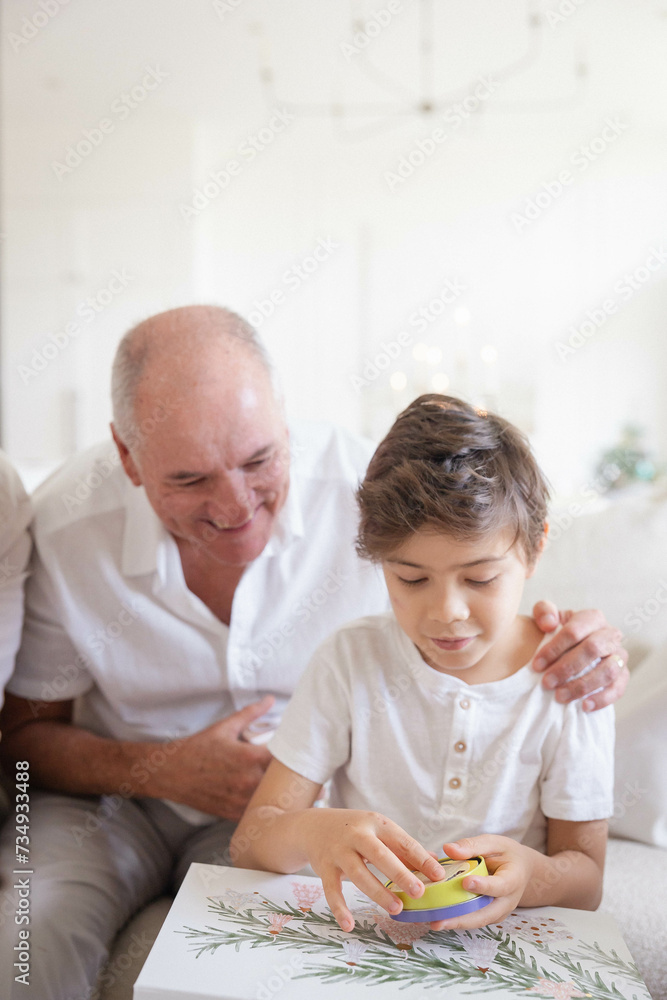 Grandad with grandson opening Christmas present Grandad with grandson opening Christmas present