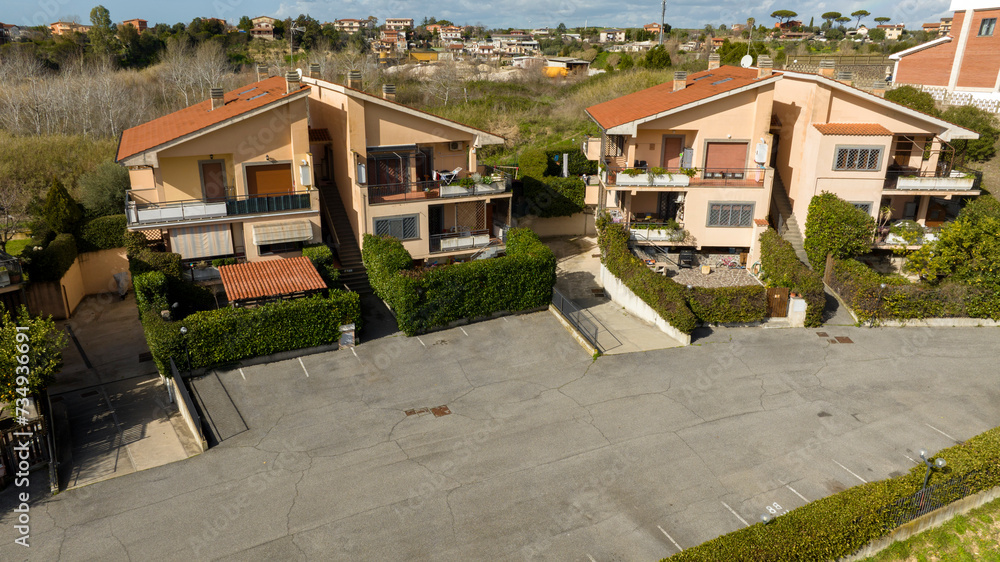 Aerial view on small terraced villas built in a residential area. All houses have their own garden.