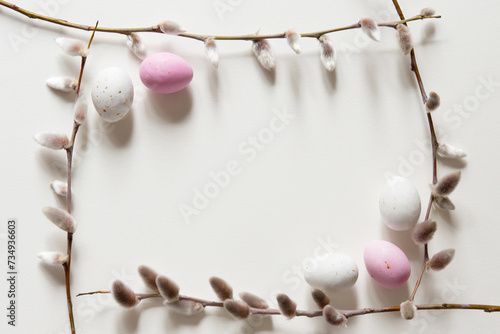 Easter composition with a willow branch and white quail eggs on a light gray background. Springtime and Easter holiday concept with copy space. Top view, Flat lay photo