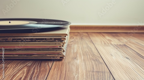 A stack of vinyl records on the wooden floor.