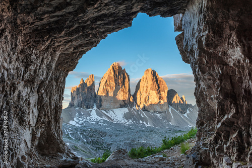 View from the cave on famous mountain peaks Tre Cime di Lavaredo, Sexten Dolomites, South Tyrol, Italy at sunrise. Drei Zinnen mountains in national park, Trentino Alto Adige