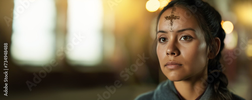 Humble woman with an ashen cross on her forehead in temple. Ash wednesday