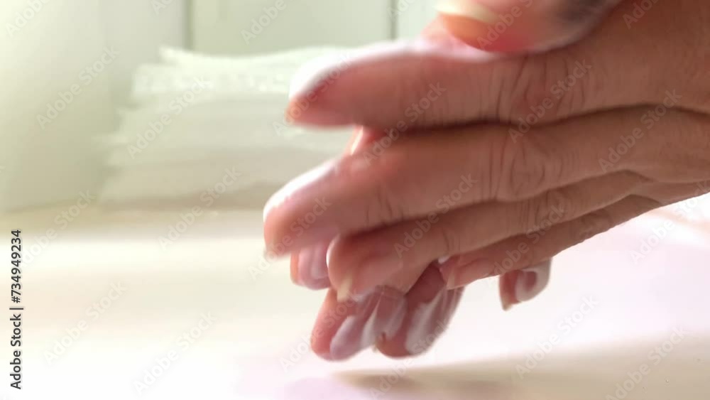Close-up of female hands rubbing thick white cream into dry, fading skin. treatment of hands for dryness in a beauty salon. old hand skin skin moisturizing cream in lotion form. Wrinkles on the hands. Close-up of female hands rubbing thick white cream into dry, fading skin. treatment of hands for dryness in a beauty salon. old hand skin skin moisturizing cream in lotion form. Wrinkles on the hands.