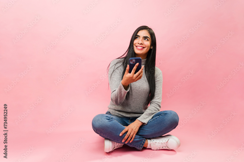 Attractive thoughtful latin woman using her phone texting Attractive thoughtful latin woman using her phone texting