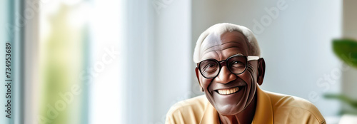 natural portrait of a senior elderly black skinned man with a gift box, blurred home interior background