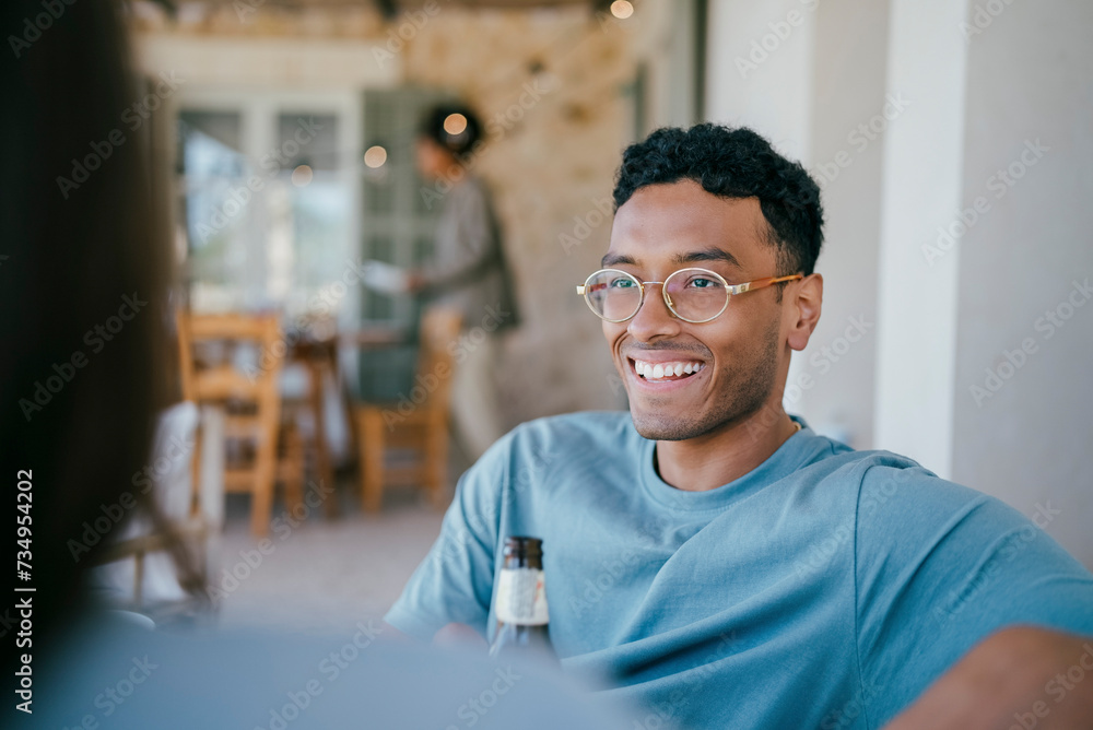 Happy young man talking with woman sitting in patio Happy young man talking with woman sitting in patio