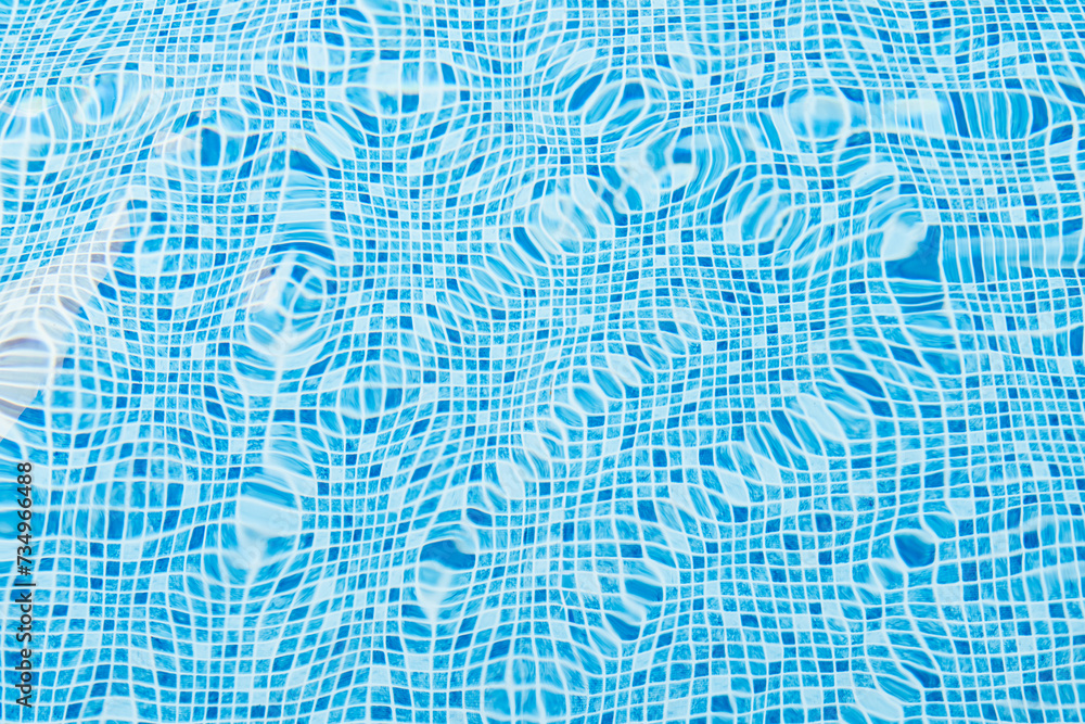 Rippling water surface in a bright blue tiled pool Rippling water surface in a bright blue tiled pool