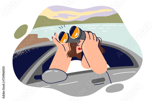Woman traveler uses binoculars while looking out car to view beauty nature and surrounding landscape