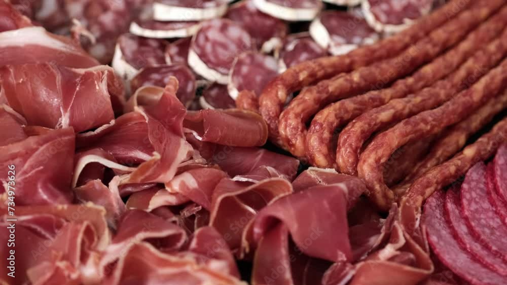 Meat plate with assortment of various tasty Spanish, french or Italian appetizers - sliced prosciutto, sausage, salami, kabanos sausages, fuet. Meat platter rotating Meat plate with assortment of various tasty Spanish, french or Italian appetizers - sliced prosciutto, sausage, salami, kabanos sausages, fuet. Meat platter rotating