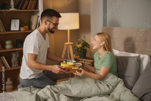 Fotografie Young man bringing his wife breakfast in bed
