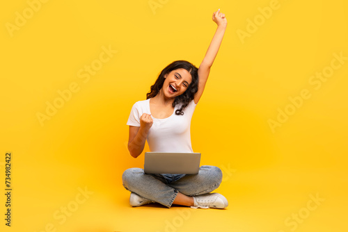 emotional young indian woman with computer on her lap © Prostock-studio