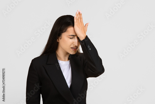 Billede på lærred Regretful businesswoman with hand on forehead in forgetful moment
