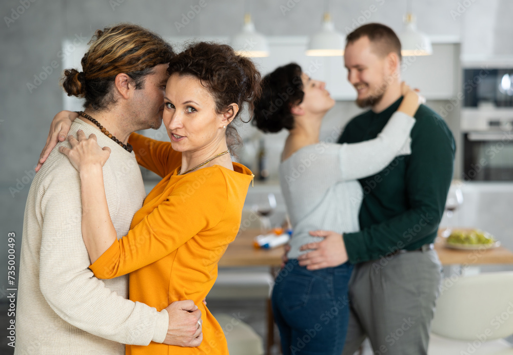 Fototapeta premium Friends dancing. Cheerful young people dancing and drinking while enjoying home party on the room