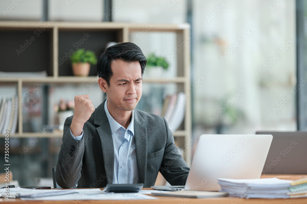 Young Businessman Using Laptop Computer in Modern Office. Manager Thinks About Successful Financial Ideas. Happy Man Smiling About Finding Problem Solving Solutions for Company. Young Businessman Using Laptop Computer in Modern Office. Manager Thinks About Successful Financial Ideas. Happy Man Smiling About Finding Problem Solving Solutions for Company.
