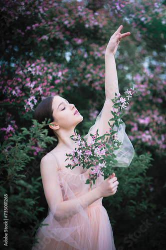 Outdoor portret of beautiful young woman surrounded by flowers. Spring blossom