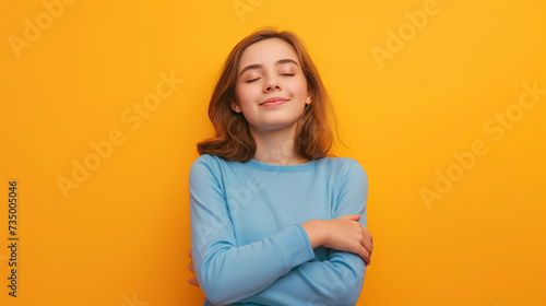 Retrato de uma linda jovem com os olhos fechados sobre um fundo amarelo photo