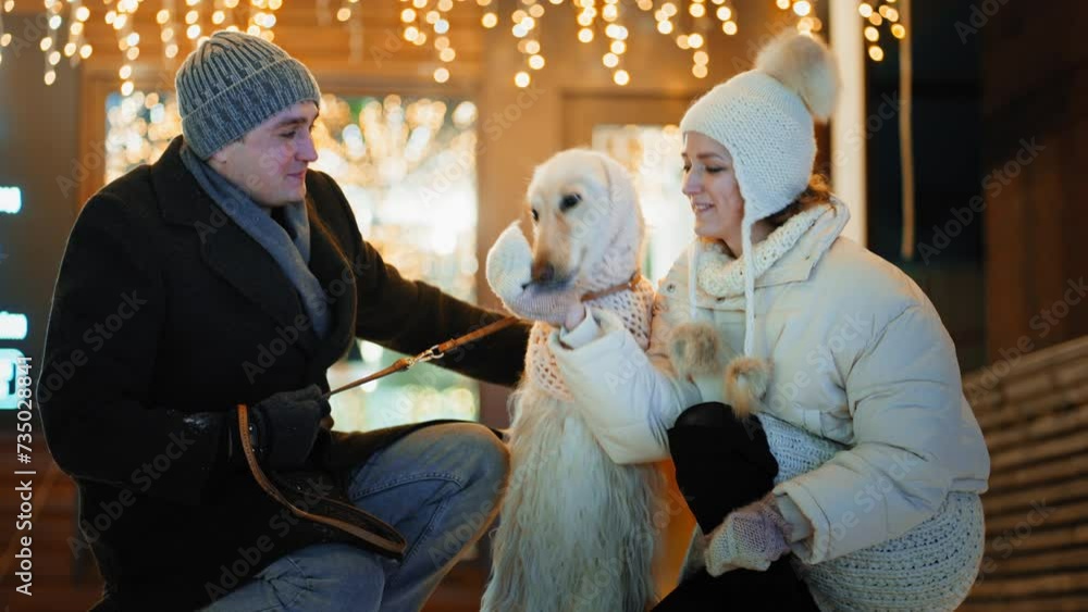 Couple walking with a dog on decorated street Couple walking with a dog on decorated street