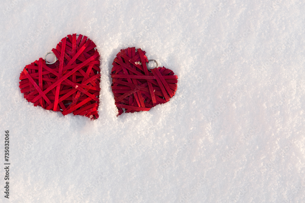 Happy valentines day background with two red hearts on white snow .