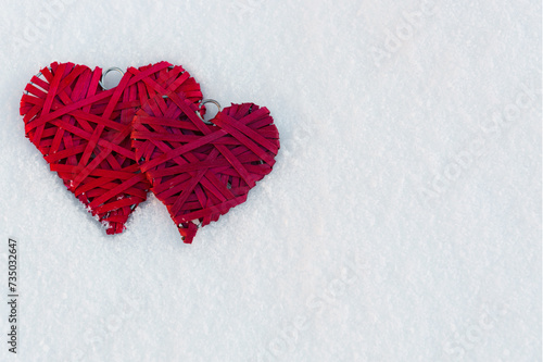Happy valentines day background with two red hearts on white snow .