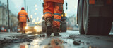 Transport workers in orange reflective vests prepare the old road surface for repair and cleaning