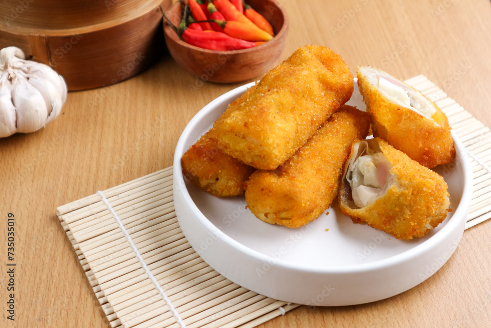 kue risoles mayo (risoles mayo cake) on wooden tray and penaut sauce served on table top. risoles mayo cake is one of popular indonesian foods. kue risoles mayo (risoles mayo cake) on wooden tray and penaut sauce served on table top. risoles mayo cake is one of popular indonesian foods.